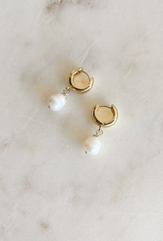 Elevate your style with our Can't Compare Huggie Earrings! These chic gold huggie earrings feature a stunning pearl drop, adding a touch of sophistication to any outfit. Perfect for any occasion, you will constantly find yourself reaching for these earrings! Gold dipped Snap closure Approximatley 1.25" in length Pearl White Dangle Earrings For Everyday, Pearl White Drop Earrings For Everyday Wear, Everyday Pearl White Drop Earrings, Single Pearl Huggie Hoop Earring, White Pearl Huggie Earrings With Pearl Charm, Gold Pearl Drop Cartilage Earrings As Gift, Hypoallergenic Pearl Huggie Earrings, White Pearl Huggie Earrings In Dainty Style, Everyday Pearl Charm Dangle Huggie Earrings