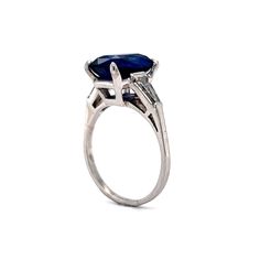 This stunning engagement ring features a 4.18 carat sapphire in platinum. A collection of .32 carats of tapered baguettes flank the center stone. Sparkling and royal in color! The deep blue sapphire is simply incredible, with a fabulous facet structure creating amazing refraction and a diverse range of blue colors. This is a truly special engagement ring with a clean design and a memorable center stone. Platinum Sapphire Ring With Baguette Cut, Sapphire Baguette Cut Platinum Ring, Baguette Cut Sapphire Platinum Ring, Lab-created Sapphire Baguette Cut Ring With Center Stone, Lab-created Sapphire Ring With Baguette Cut, Classic Sapphire Ring With Baguette Cut, Classic Baguette Cut Sapphire Ring, Formal Baguette Cut Solitaire Sapphire Ring, Classic Baguette Cut Sapphire Ring With Polished Finish