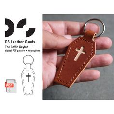 a hand holding a leather keychain with a cross on it and the text ds leather goods