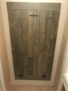 a wooden door in the corner of a bathroom