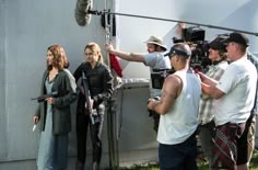 a group of people standing next to each other in front of a building with cameras