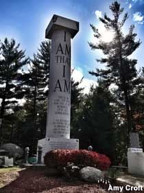 a large white cross sitting in the middle of a cemetery