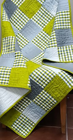 a green and gray quilt on a chair