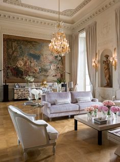 a living room filled with furniture and a chandelier