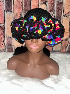 a mannequin head wearing a multicolored hat