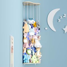 there is a wall clock with many stuffed animals in the cage hanging from it's sides