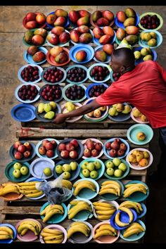 a man standing in front of a table full of fruit