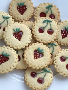 small cookies with cherries are arranged on a plate