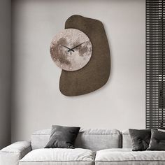 a living room with a couch and large clock on the wall