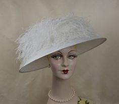 Ooh, la la!  Masses of frothy feathers adorn this elegant showstopper.  Light and airy, this fashionable ladies hat has a very wide brim and is a lovely white shade, ideal for a wedding or special event - a soft yet dramatic feminine look!   This hat is handmade and hand-blocked in white, parasisal straw.  Very full and fluffy ostrich feathers surround the crown creating a distinctive and unexpected silhouette. Style - White Parfait Brim measures 5 inches. May be made to order in your hat size, Ostrich Feather Trim Fascinator Hat, Elegant Summer Fascinator With Feather Trim, Chic Summer Fascinator With Feathers, Ostrich Feather Hats For Royal Ascot Wedding, Ostrich Feather Hat For Royal Ascot Races, Chic Fascinator With Feathers For Royal Ascot, Wide Brim Feather Trim Fascinator For Races, Wide Brim Fascinator With Feather Trim For Races, Elegant Ostrich Feather Fascinator