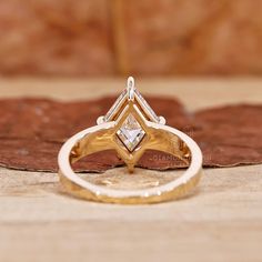 a diamond ring sitting on top of a wooden table next to a piece of wood