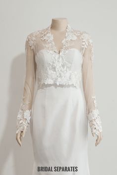 a white dress with sheer sleeves and flowers on it