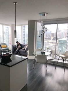 a man sitting on top of a couch in a living room next to a window