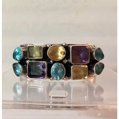 This is part of Chairish’s Fine Jewelry assortment.  This stunning vintage Sterling Cuff Bracelet with Semi Precious Stones will be a fabulous addition to your jewelry collection. The semi-precious stones (blue topaz, citrine, aquamarine, peridot and amethyst) in a variety of shapes and set in heavy gauge sterling silver make this Paul Livingston piece a real standout. Formal or casual, this beautiful Native American sterling bangle will be your go to when you want to impress. From my personal c Multicolor Multi-stone Bangle, Fusion Style Gemstone Cuff Bracelet, Multicolor Multi-stone Bangle As A Gift, Multicolor Multi-stone Unique Bracelets, Unique Multi-stone Bangle Bracelet, Unique Multi-stone Bangle Bracelets, Unique Multi-stone Bangle, Unique Multi-stone Bangle Jewelry, Bohemian Multi-stone Gemstones For Anniversary