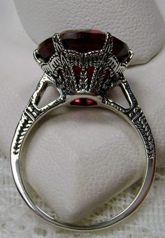 Simulated Red Ruby Ring Description 100 Year Design#37 Custom This is a brand new Edwardian reproduction filigree ring in antiqued solid sterling silver. The round full cut high quality Simulated/man-made red ruby gemstone is 12mm (1/2th of an inch) in diameter. The inside of the band is marked 925 for sterling. Notice the beautiful intricate crown like design of the silver filigree setting and etched band. The original ring I bought in this exact design was from 1910. This is a rare and exact r Classic Oval Engraved Ruby Ring, Red Ruby Filigree Ring For Wedding, Red Victorian Filigree Ring For Anniversary, Collectible Red Engraved Ring, Vintage Ruby Ring With Filigree For Wedding, Red Vintage Filigree Ring With Gemstone, Red Victorian Filigree Ring With Gemstone, Red Ruby Filigree Ring, Art Deco Ruby Ring For Formal Occasions