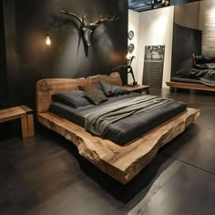 a large bed sitting on top of a wooden floor next to a wall mounted deer head