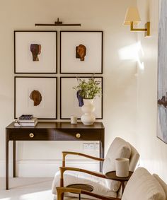 a living room with pictures on the wall and a chair in front of a table