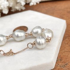 14KT rose gold + genuine, cultured Paspaley South Sea Pearl bracelet with a toggle clasp. Bracelet includes: (8) 12mm, genuine, cabochon, "Fine" quality, "Circle" shape, Paspaley Pearls + (8) South Sea Pearl spacers. This bracelet is a sure stunner with a polished, ornate texture and beautiful south sea pearls. Made to order piece: please allow 5-7 days for creation prior to shipping. Also available in 7" length. 7" length will include only 7 Paspaley South Sea pearls. Choose your length Bracele Timeless Round Pearl Bracelet As Gift, Formal Hypoallergenic Jewelry With Round Beads, Hypoallergenic Formal Jewelry With Round Beads, Hypoallergenic Round Bead Jewelry For Formal Occasions, Luxury Single Strand Bracelet As Gift, Rose Gold High Luster Jewelry For Gift, Timeless Jewelry With Round Beads As Gift, Timeless Round Beads Jewelry As Gift, Timeless Round Beads Jewelry Gift