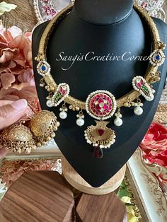 This brass-based textured matte antique gold  finish Hasli (necklace style) and dainty jhumka earring set has a very gorgeous Paachi Kundan and jadau accents throughout the piece. The color combination with pearl embellishments and ghungooroo embellishments brings the whole piece together really well. The hasli itself is handcarved with beautiful textures through out the piece. Again, this has an antique gold lookalike brass-based metal finish with jadau and kundan stones. The combination of stone color with an antique silver brass-based metal finish makes you look royal with a fusion edge.  The set comes with dainty jadau clear kundan stone with pearl drops. There is a separate picture of earrings, please check it out.  Two multi color combinations with or without earrings options are ava Festive Chandbali Jewelry With Antique Finish, Gold Oxidized Kundan Necklace For Festivals, Festive Gold Kundan Necklace With Oxidized Finish, Gold Jewelry Sets With Oxidized Finish For Festive Occasions, Wedding Brass Temple Necklace With Antique Finish, Handmade Metal Kundan Necklace For Festive Occasions, Festive Brass Kundan Necklace With Intricate Design, Ornate Brass Kundan Necklace For Gift, Festive Oxidized Brass Kundan Necklace