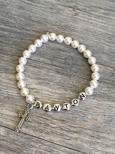 "Personalized first communion pearl bracelet, confirmation gift, jewelry, first communion gift, first communion bracelet, pearl bracelet A beautiful 6mm Swarovksi Crystal Pearl bracelet made just for that special someone! Please let me know the name you want on the bracelet when you checkout. Also, if you could select the child's age this will help me size it correctly. I use stretch magic so the bracelet can easily slip on and off. Bracelet pictured was made with Cream pearls and TierraCast Ant Classic Personalized White Pearl Bracelet, Pearl Charm Jewelry For First Communion, First Communion Pearl Drop Jewelry, Personalized Round Bead Bracelets For Baptism, Personalized White Beaded Bracelets For Baptism, Pearl Charm Bracelet For First Communion, Personalized White Bracelet For Confirmation, Personalized White Bracelets For Confirmation, Pearl Bracelet For First Communion