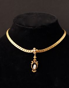 This is a gorgeous signed Miriam Haskell gold tone choker necklace that features a stunning drop lavaliere style pendant with faux pearls and etched gold floral detail. The pendant measures 1.9 inches in length. The necklace has a hook clasp and is adjustable between 14 and 17 inches. The piece is signed with a hang tag as well as on the hook itself as pictured. The necklace is in great vintage condition with some beautiful vintage patina.  I do not routinely pack in gift boxes to prevent excess waste. Your item will be in a clear plastic baggie and securely padded for transport.   I am not a professional jewelry expert, and the information provided in this listing is based on my best knowledge and research. The vintage piece(s) you are considering is being sold as-is, and I encourage you Victorian Gold Pearl Necklace Gift, Victorian Gold Choker Necklace, Vintage Gold Handmade Choker, Victorian Gold Brass Necklace, Vintage Brass Choker Necklace, Designer Necklace, Choker Pendant, Miriam Haskell, Royal Dresses