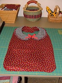 an apron is sitting on top of a cutting board next to some baskets and scissors