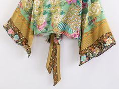 Our beautiful Metella Boho Kimono has a bold and vibrant floral with peacocks print design. Made from a lightweight cotton blend that will look great both as a summer layer or on the beach.Specs: Material: Cotton/ Rayon Fits true to size, take your normal size Spring Beachwear Top With Vibrant Print, Vibrant Printed Green Tops, Spring Yellow Tops With Printed Motifs, Vibrant Green Printed Tops, Tropical Patterned Top With Floral Print, Bohemian Top With Bold Print For Spring, Bohemian Bold Print Top For Spring, Bohemian Tops With Bold Print For Spring, Tropical Patterned Tops With Floral Print