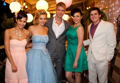 a group of people standing next to each other in front of a table with lights on it