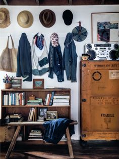 a room filled with lots of hats hanging on the wall next to a book shelf