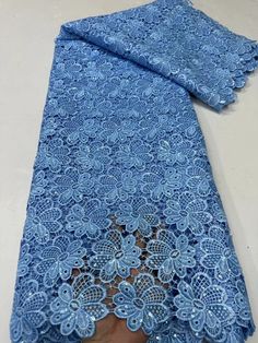 a blue lace fabric with flowers on it