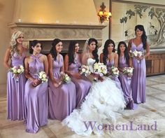 a group of women standing next to each other in purple dresses and holding bouquets