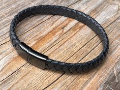 Zwart lederen gevlochten heren armband met roestvrij stalen sluiting Zwart echt leder 8 mm Roestvrij stalen zwarte sluiting. Andere kleuren ook verkrijgbaar in onze shop. Twijfel over de maat ? Meet uw pols omtrek om de knobbel op uw pols. Tel hierbij 1,5 cm op voor een strakkere zittende armband. Tel hierbij 2 cm op voor een normaal zittende armband Tel hierbij 3 cm op voor een wat ruimere armband Indien er vragen zijn neem gerust contact op met ons wij helpen u graag verder. Makkelijk te drage Masculine Black Leather Bracelet With Stainless Steel, Black Braided Bracelet With Stainless Steel Clasp As Gift, Black Braided Bracelets With Stainless Steel Clasp As Gift, Black Braided Bracelet With Stainless Steel Clasp, Burgundy Bracelet, Engraved Leather Bracelets, Personalized Leather Bracelet, Brown Leather Bracelet, Brown Bracelet