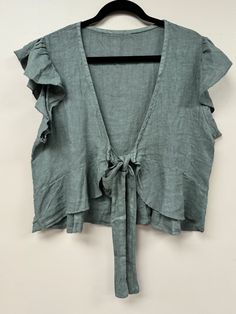 Elevate your wardrobe with our Italian versatile cropped tie top. Crafted in Italy, this elegant piece can be worn front or back, featuring a delicate bow detail and ruffled short sleeves. The perfect blend of sophistication and fun, available in one size. Chic Short Sleeve Crop Top For Vacation, Summer Cropped Top With Tie Waist, Cropped Tie Waist Tops For Summer, Summer Crop Top With Tie Back And Short Sleeves, Solid Color Summer Top With Tie Waist, Solid Summer Top With Tie Waist, Summer Solid Top With Tie Waist, Summer Solid Color Tops With Tie Waist, Chic Short Sleeve Crop Top With Ruffles