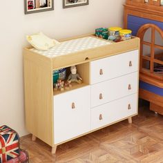 a baby crib in a child's room with pictures on the wall above it