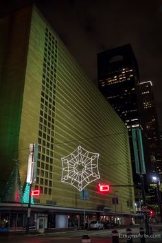 a large building with christmas decorations on it's side in the city at night