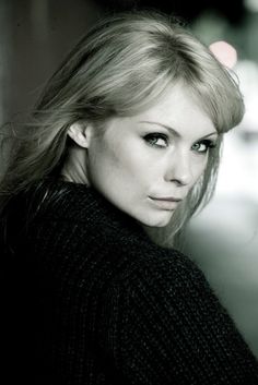 a black and white photo of a woman with long hair wearing a turtle neck sweater