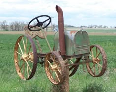 an old fashioned farm tractor sitting in the middle of a field