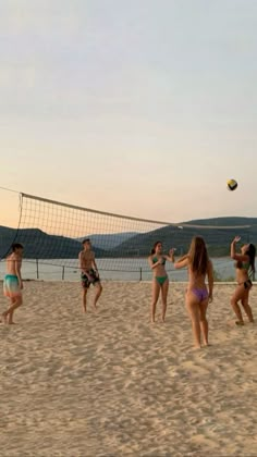 some girls are playing volleyball on the beach