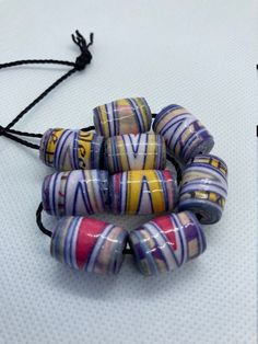 several bracelets are sitting on a white surface and one is made out of glass beads