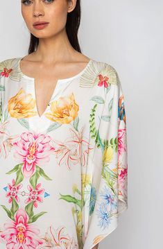 Bring out your inner flower in the Botanica Long Caftan. This gorgeous piece of apparel features delicate flowering patterns, giving you the freedom to show off your unique style. And the airy fabric won’t weigh you down, meaning you can wear your beauty around the clock! Bloom into something special with the Botanica Long Caftan. Printed short caftan Can be worn loose or cinched at the waist Comes with a matching belt as an option for styling Lusciously soft poly-silk blend for ease of care Mac Floral Print Tunic With Kimono Sleeves For Vacation, Summer Tropical Print Kaftan For Spring, Floral Print Tunic For Beach In Spring, Bohemian Blouse With Tropical Print For Beach, Floral Print Tunic For Spring Beach Outings, Summer Floral Print Kaftan For Daywear, Summer Floral Print Long Sleeve Tunic, Flowy Floral Print Tunic For Vacation, Flowy Floral Print Kaftan With Kimono Sleeves