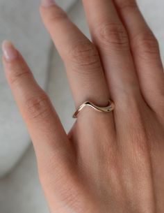 a woman's hand with a gold ring on it