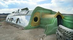 an unusual house in the middle of nowhere with solar panels on it's roof