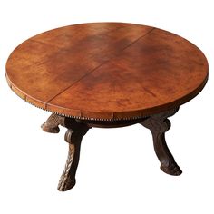 a round wooden table with carved legs