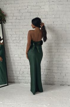 This Emerald Green Maxi Dress will make you feel elegant and special. Crafted from luxuriously smooth satin silky, the dress features a strapless silhouette with a cowl back and a waisted tie. The long length flatters any figure and makes this dress perfect for a formal occasion. emerald green strapless dramatic cowl back back bow tie relaxed fit long length 100% polyester model is wearing a small Elegant Strapless Dress With Bow Tie Back For Prom, Elegant Strapless Prom Dress With Bow Tie Back, Elegant Strapless Dress With Bow Tie Back For Evening, Elegant Evening Strapless Dress With Bow Tie Back, Party Evening Dress With Tie Back And Fitted Bodice, Party Gown With Tie Back, Maxi Length, Formal Tie Back Long Backless Dress, Elegant Strapless Dress With Bow Tie Back, Formal Backless Long Dress With Tie Back