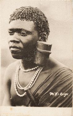 an old black and white photo of a woman with beads on her neck, wearing necklaces