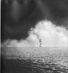 a black and white photo of a person on a surfboard in the middle of water