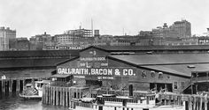 an old black and white photo of boats docked in front of a building with the name ballantia bacon & co on it