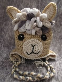 a crocheted stuffed animal wearing a hat with flowers on it's head