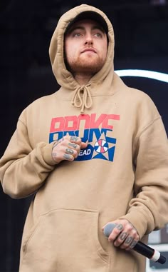 a man in a brown hoodie holding an umbrella