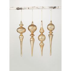 four gold colored ornaments hanging from a branch